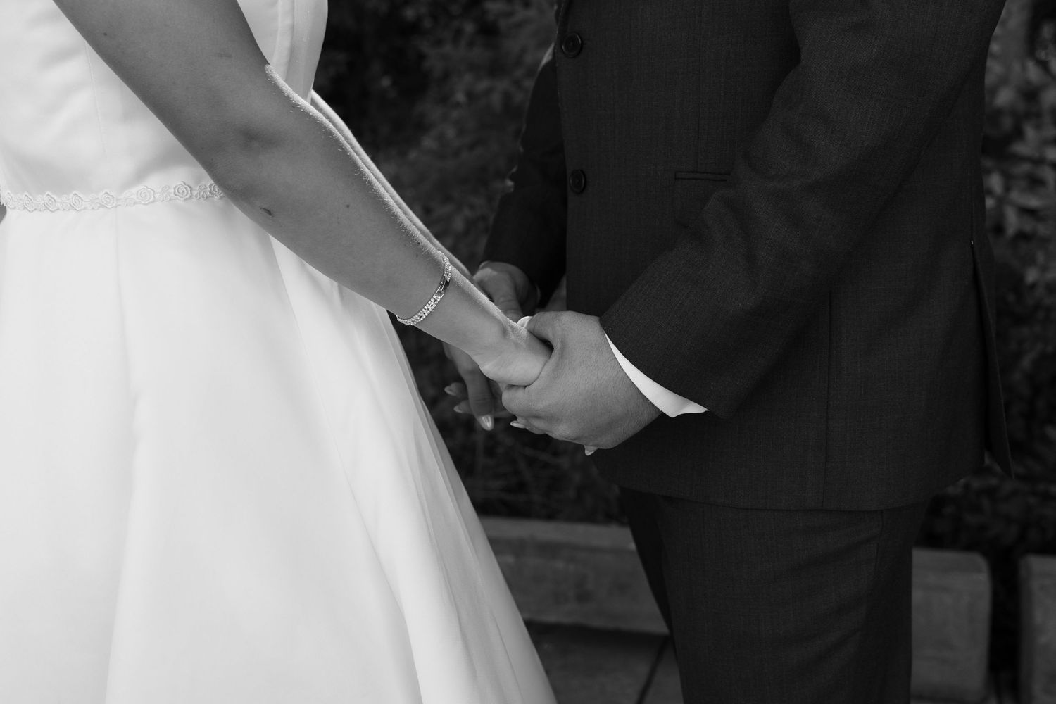 Black and white photo of a wedding couple in a tender moment.