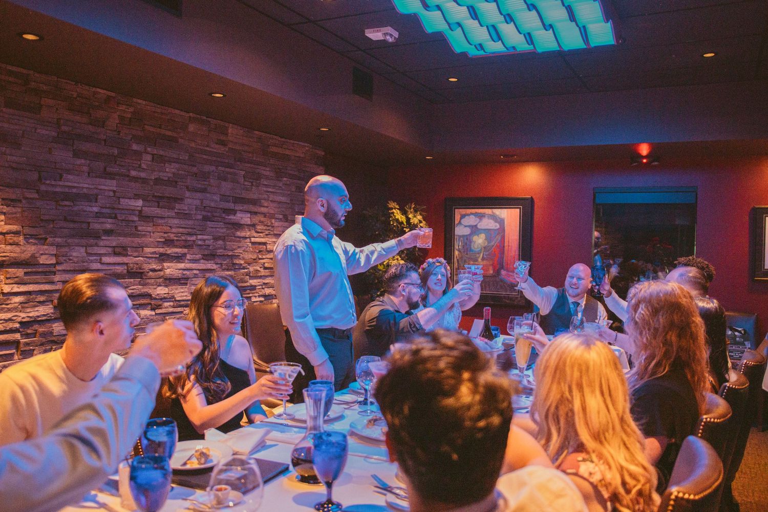 Wedding reception party with blue accent lighting and guests enjoying the celebration.