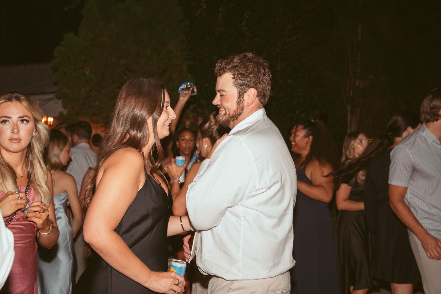 Lively dance party scene at an outdoor wedding reception with guests enjoying themselves.