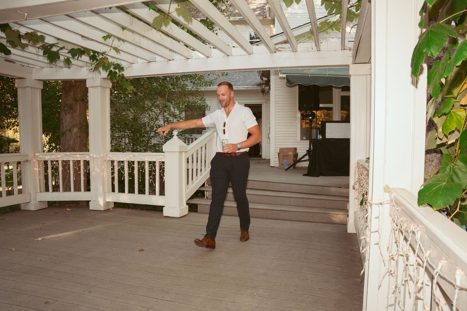 White pergola and porch area of a Victorian-style venue during daytime.
