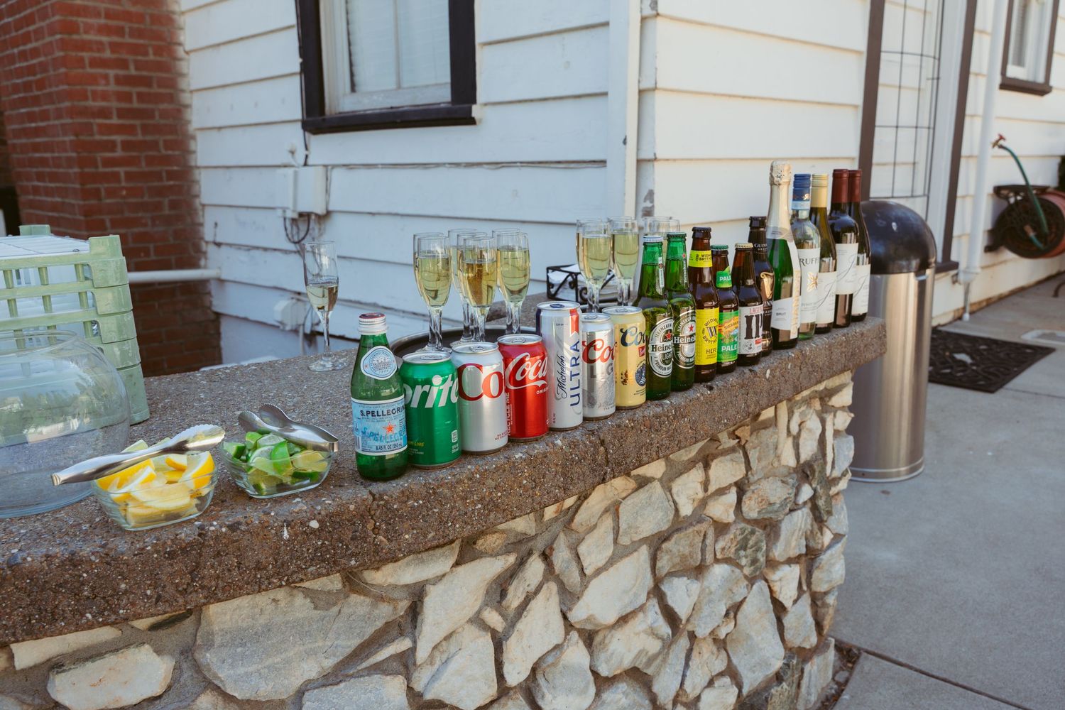Stone wall bar setup with colorful bottles displayed in a row.