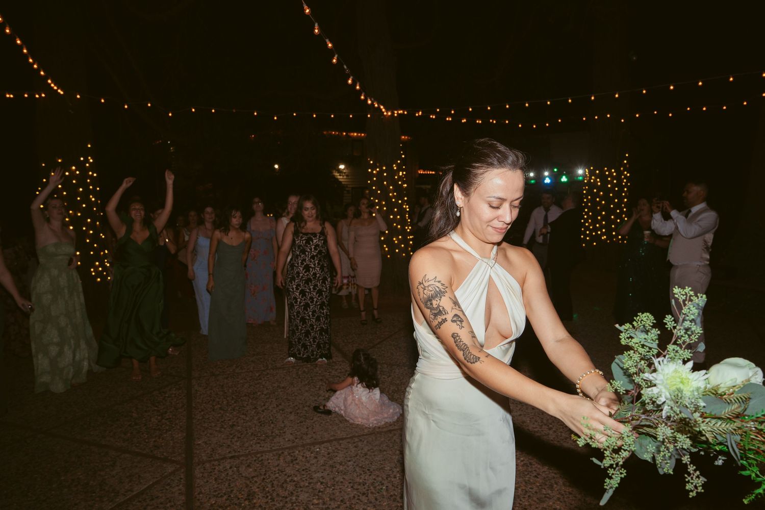 Outdoor evening wedding reception with string lights creating a romantic atmosphere.