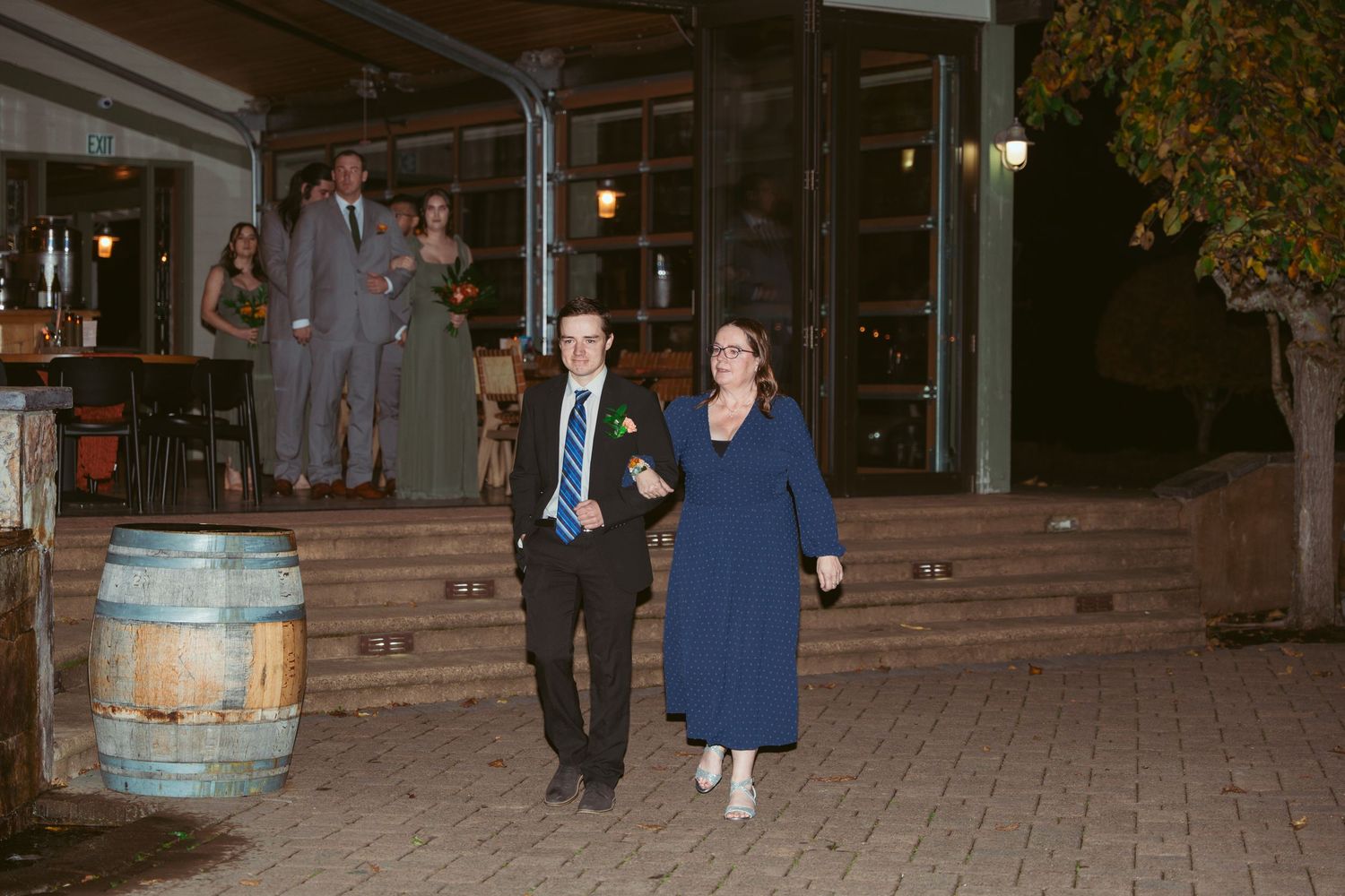 Evening wedding celebration with guests mingling on a brick patio.