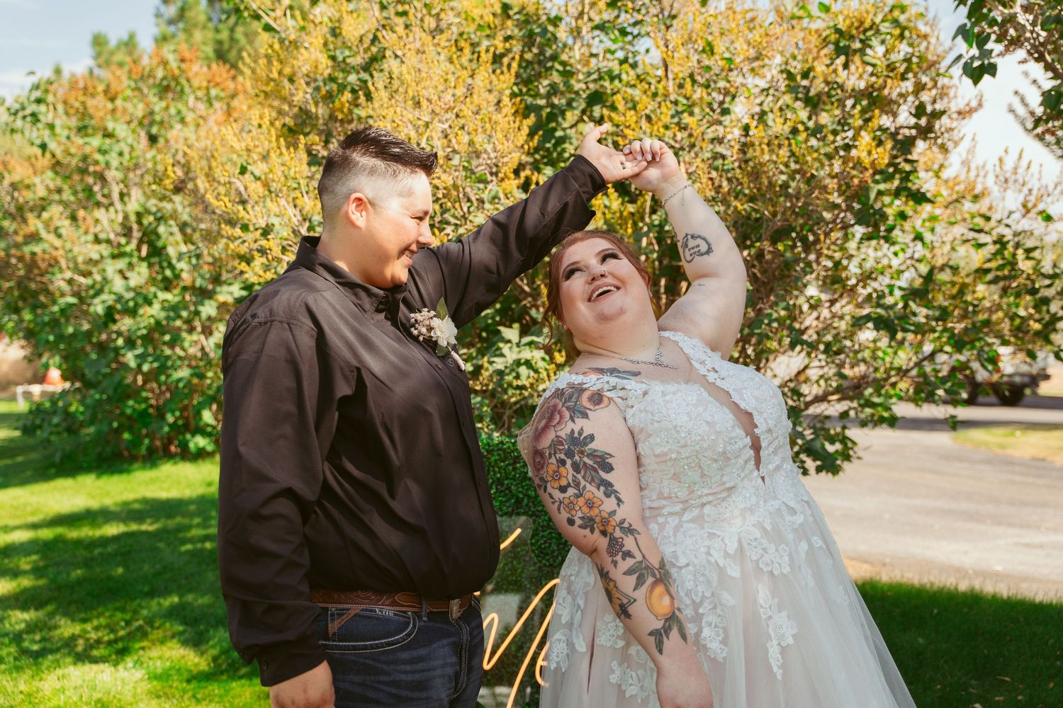A couple shares a romantic moment together in a sunlit outdoor setting with autumn trees in the background.