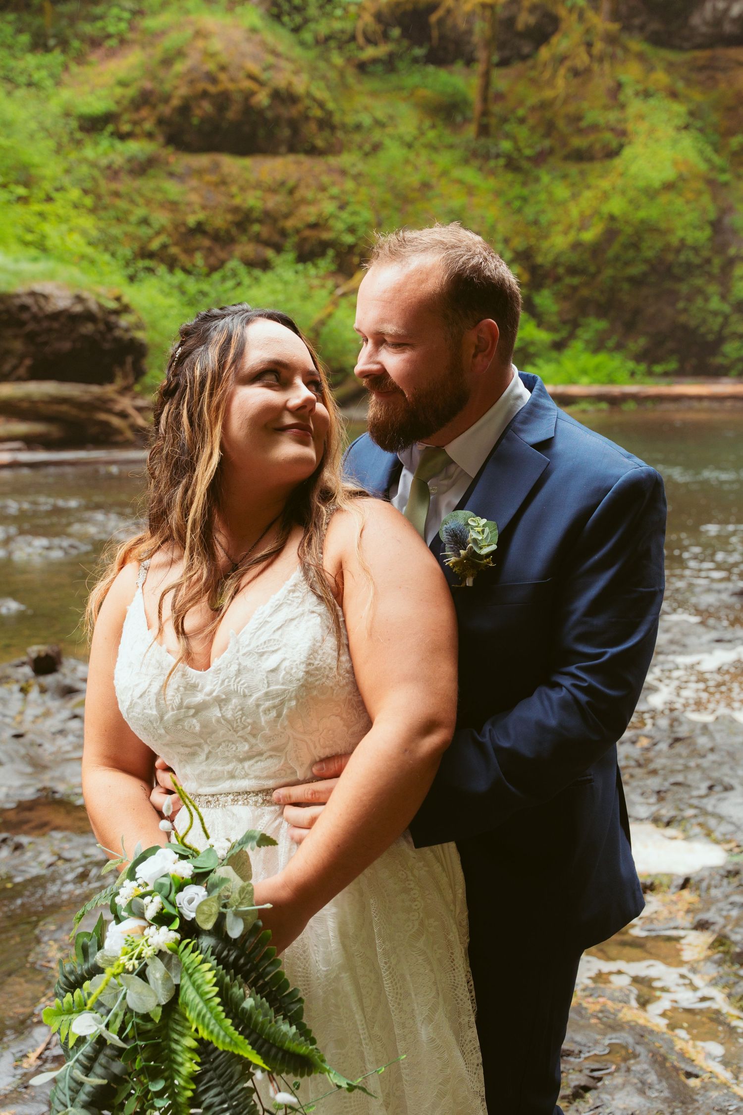 Candid wedding photos captured against the backdrop of a rushing forest waterfall.