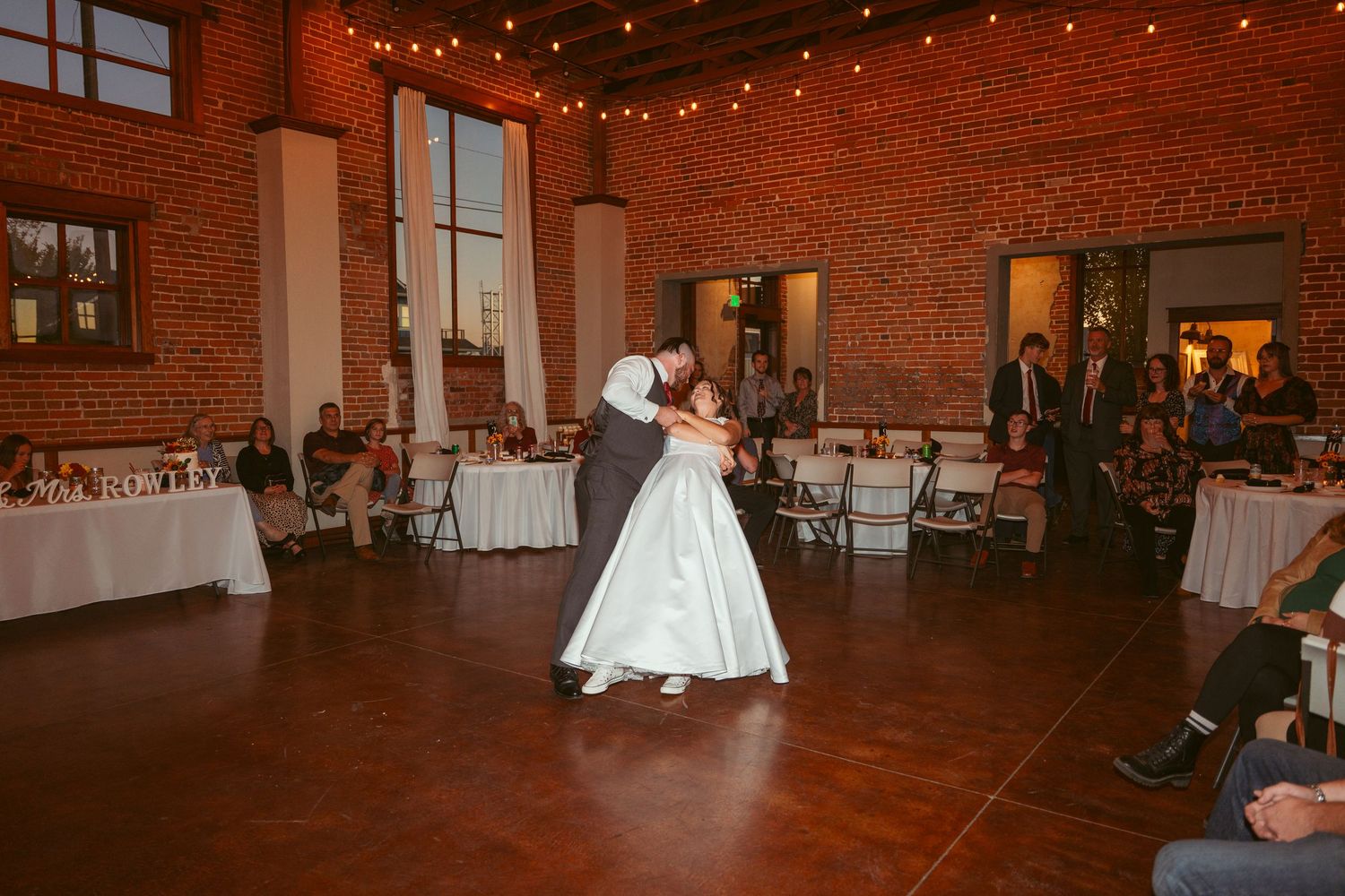 Couple dancing in an intimate moment at their wedding reception in a historic brick building.