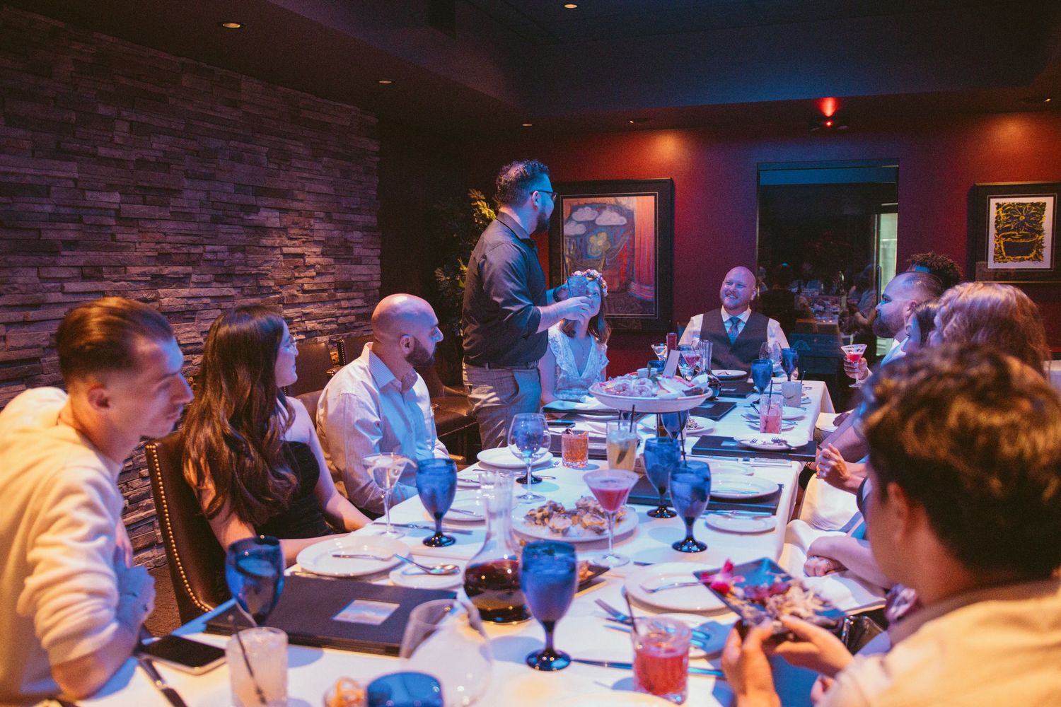Wedding reception dinner in a dimly lit restaurant with exposed brick walls.