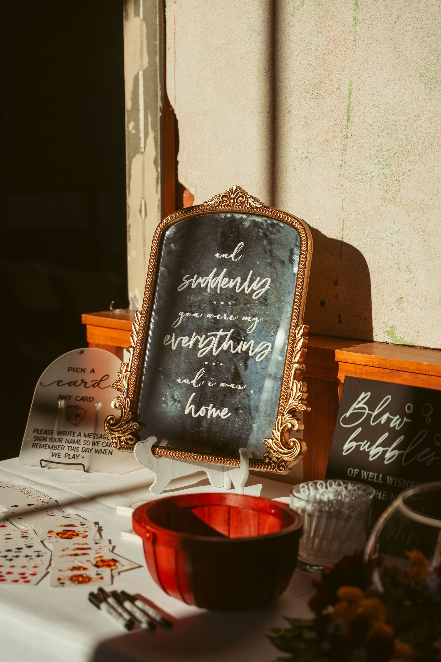 Vintage-style framed wedding signage with calligraphy displayed against a white wall.