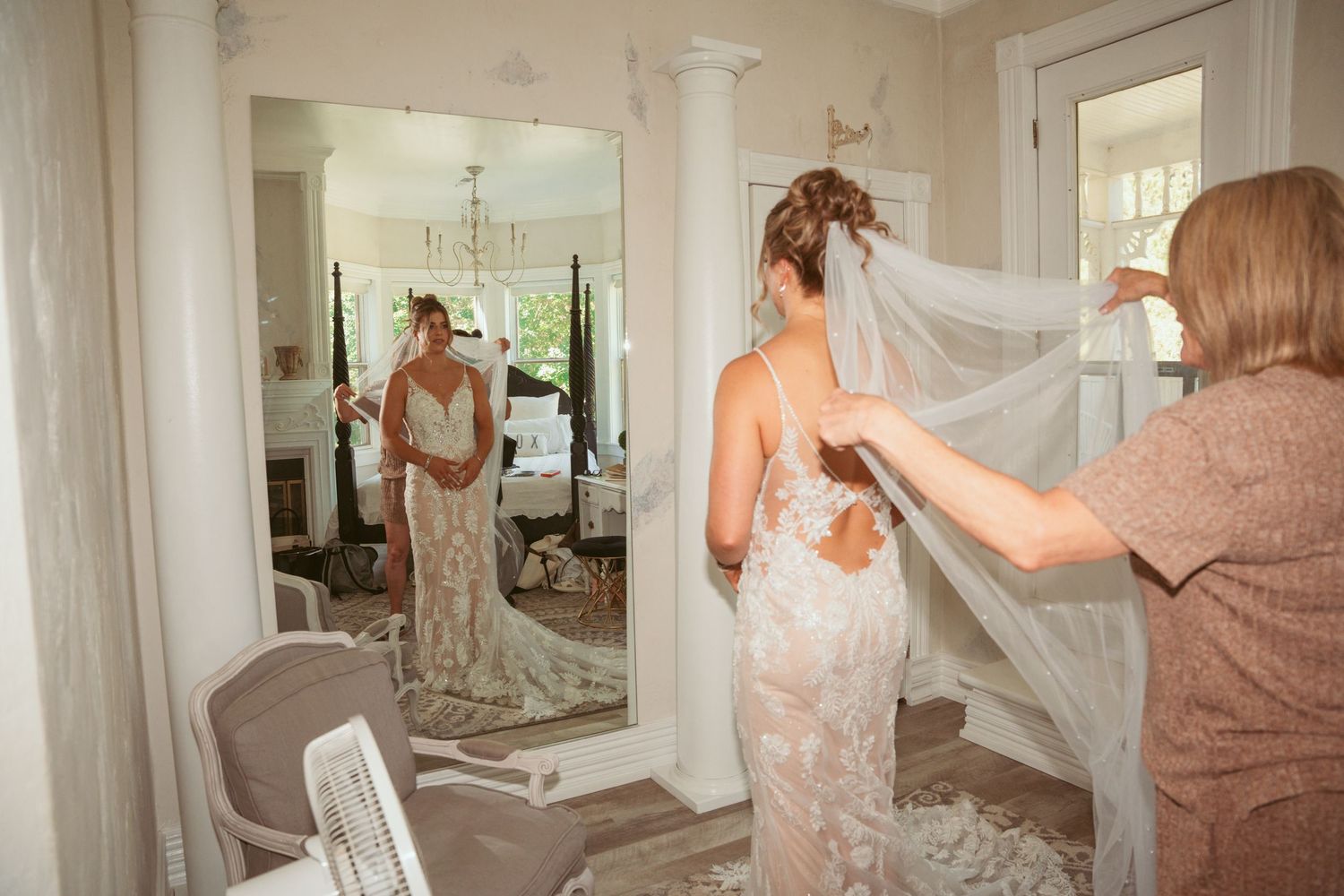 A series of bridal preparation photos showing white dresses and veils in an elegant room with chandelier lighting.