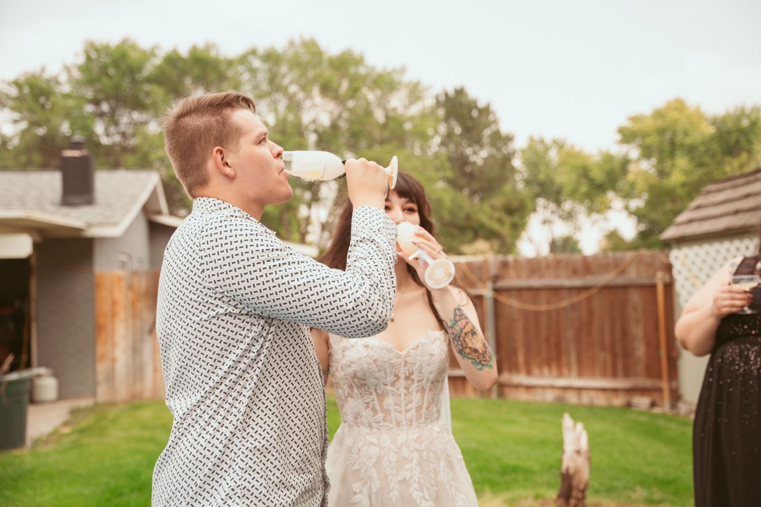 A couple shares a romantic toast outdoors with wine glasses during a special celebration.