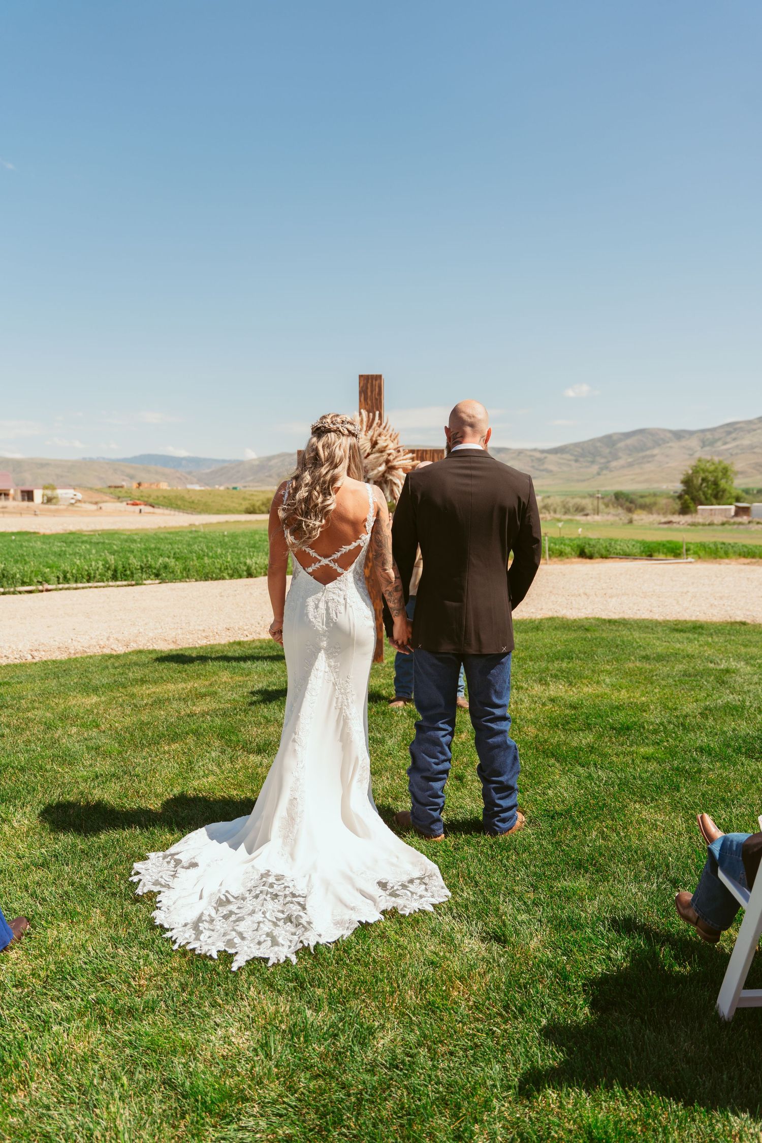 Couple standing together during outdoor wedding ceremony with mountain landscape.