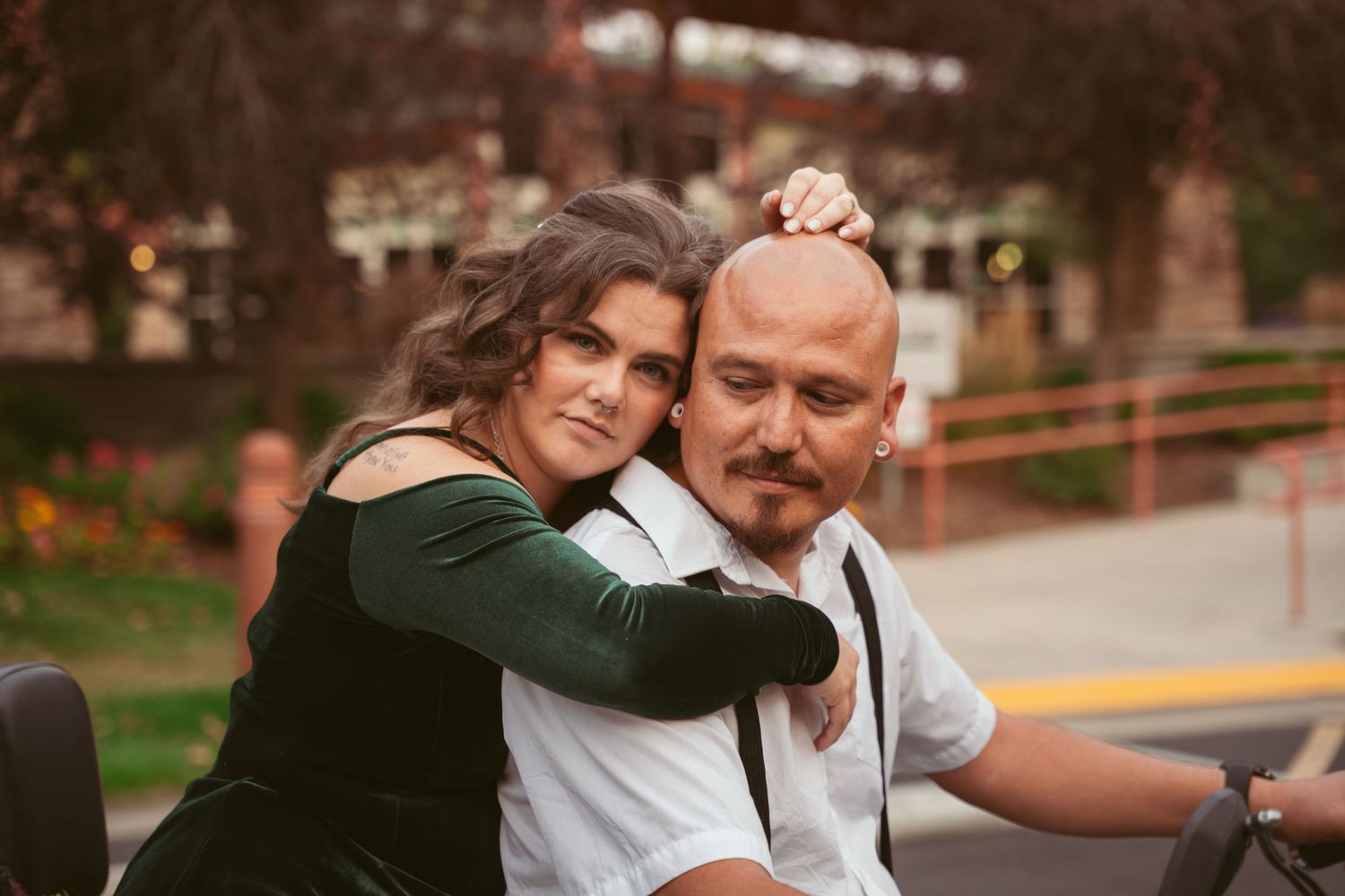 A couple embraces affectionately near a parked motorcycle.