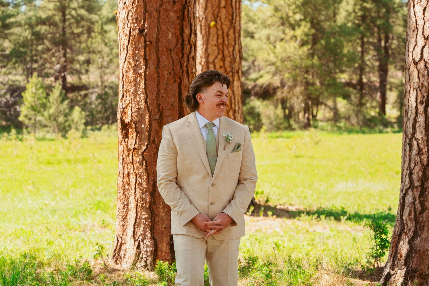 A series of candid wedding first look reactions captured in a sunny forest setting.