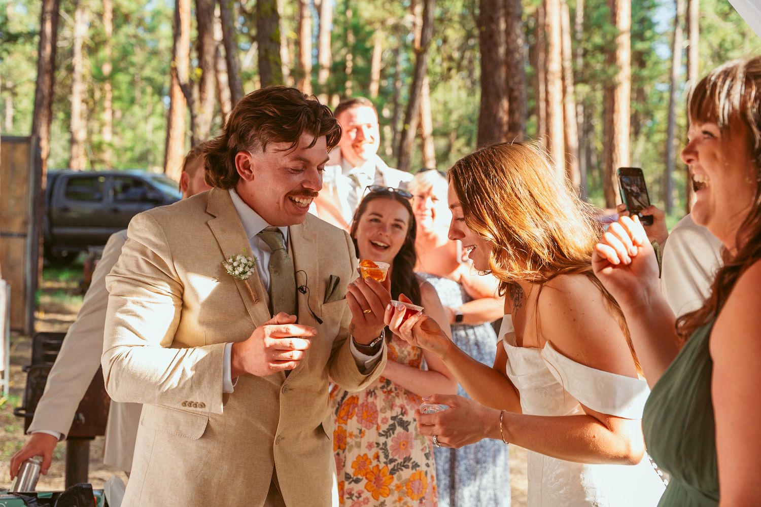 Guests enjoy dancing and celebrating at a rustic outdoor wedding reception.