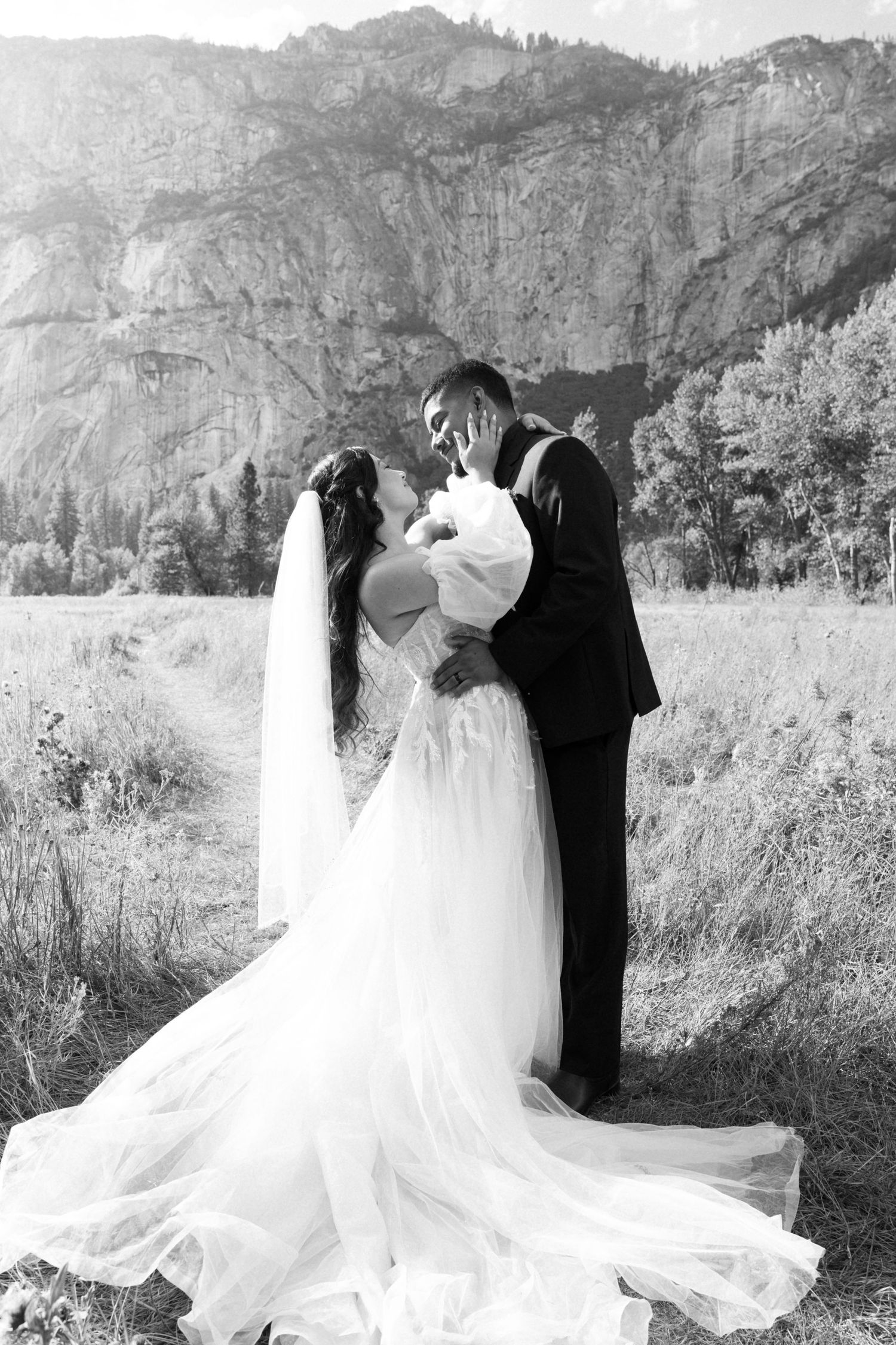 Black and white wedding portrait showing intimate moment with majestic mountain backdrop.