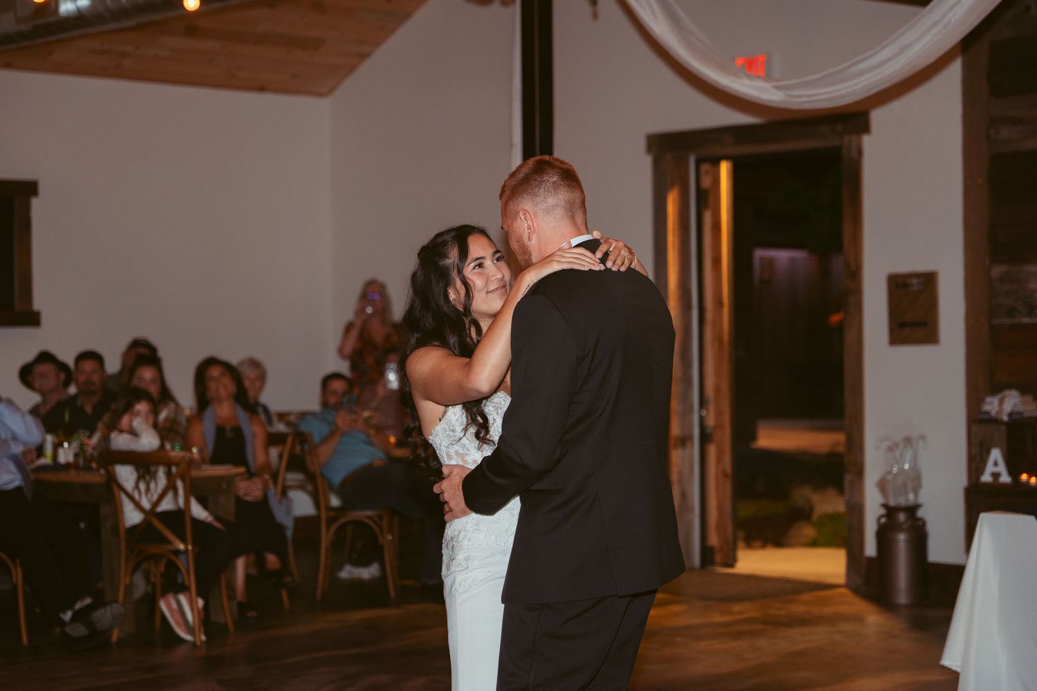 Wedding reception venue decorated with white draping and string lights.