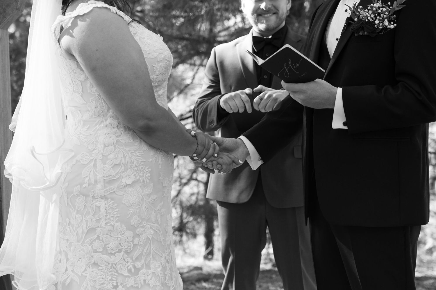 Black and white photo of wedding ceremony moments under forest canopy.