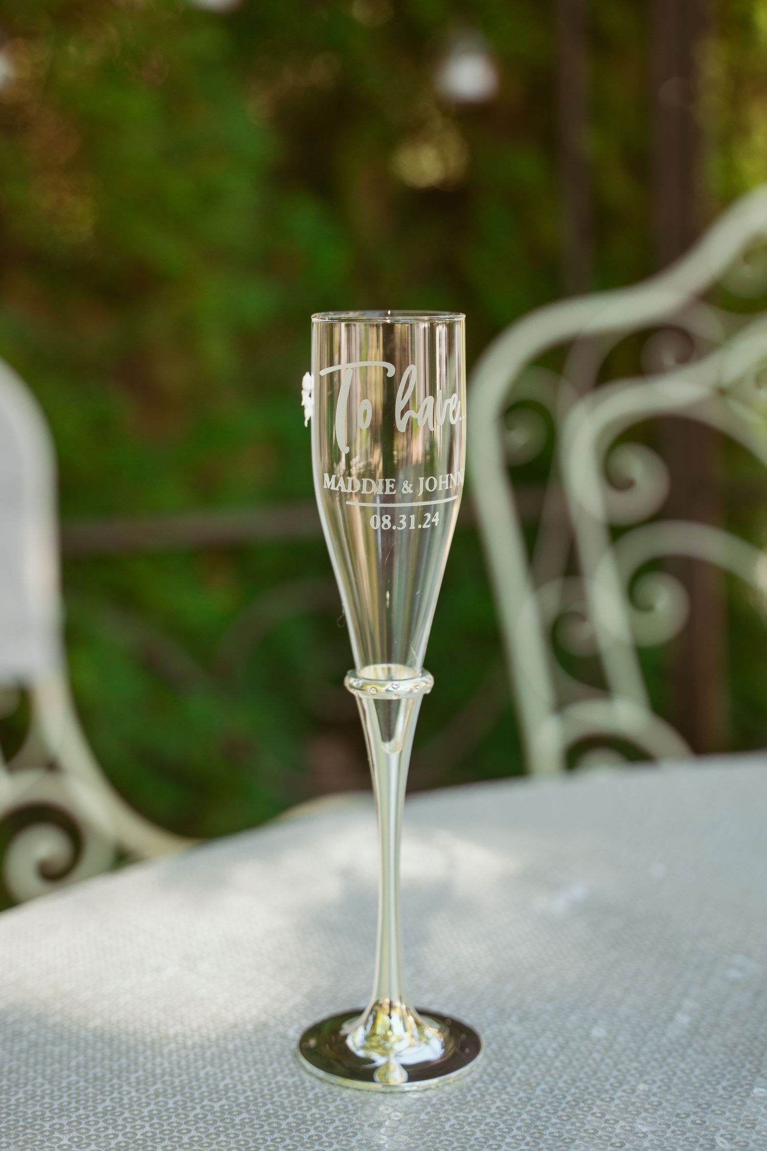 Crystal champagne flutes arranged in a row on a textured gray surface with natural lighting.