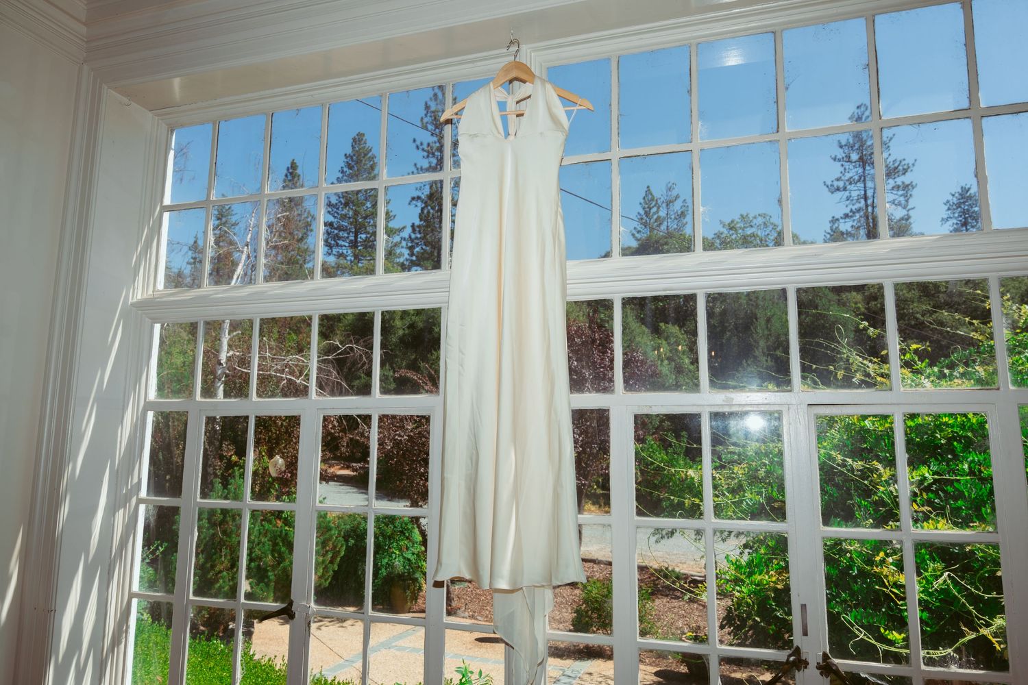 Large windows with white trim overlooking a garden setting for an event space.
