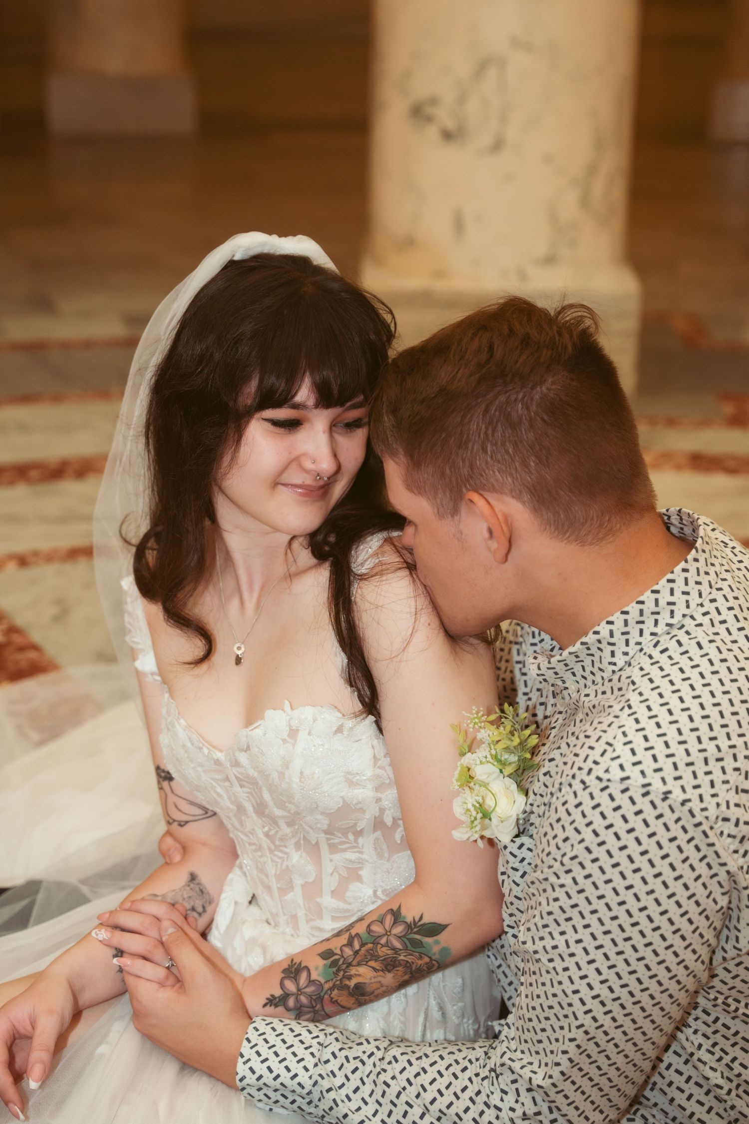 Intimate moment between couple in formal attire at indoor venue.