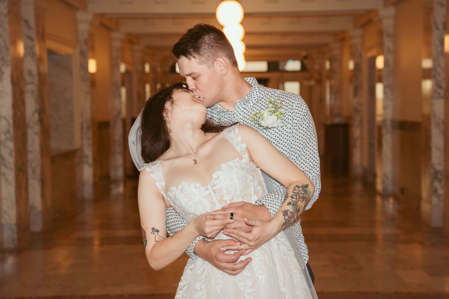 Romantic wedding photos in a warmly lit industrial corridor.