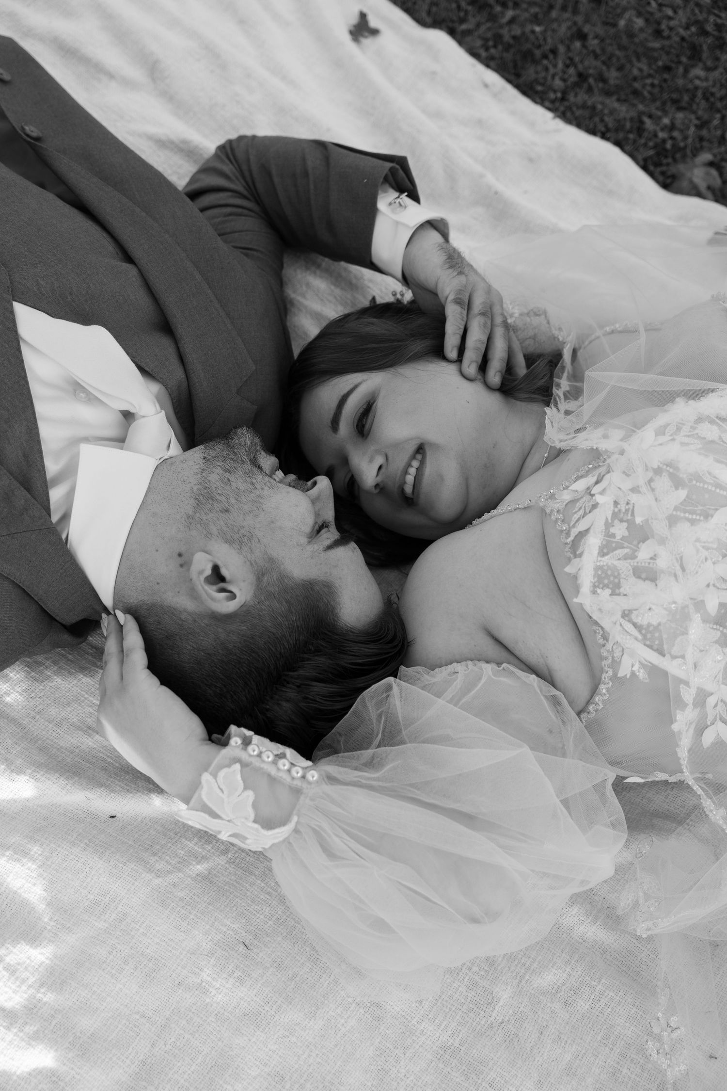 Black and white intimate wedding portrait on white fabric outdoors.