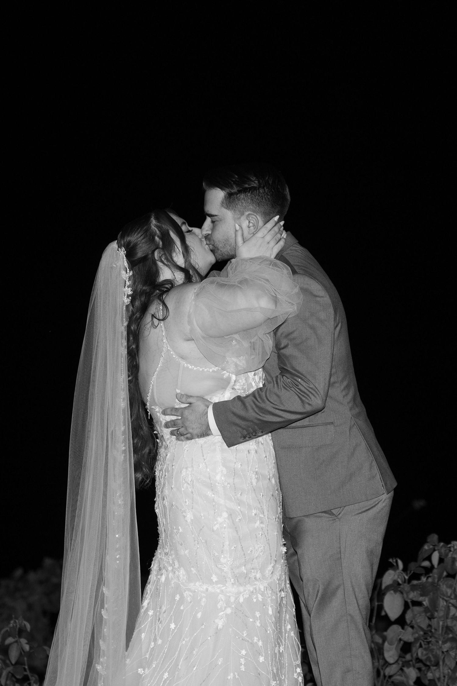 Intimate moment between couple during evening outdoor wedding ceremony.
