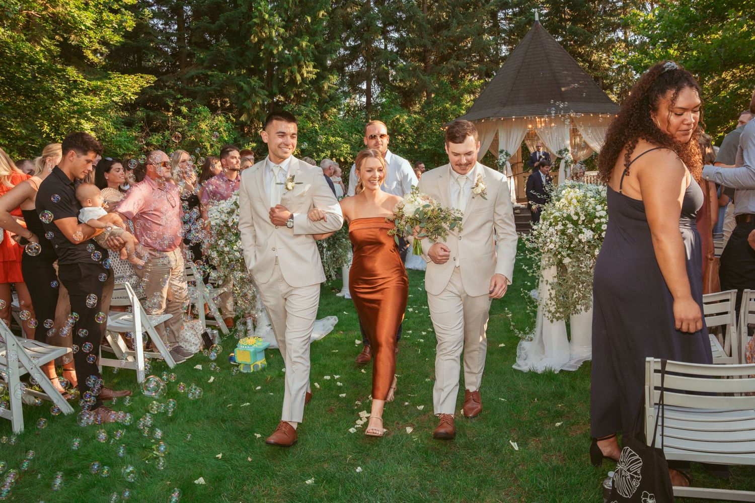 Wedding celebration in a garden setting with guests mingling on the lawn at golden hour.