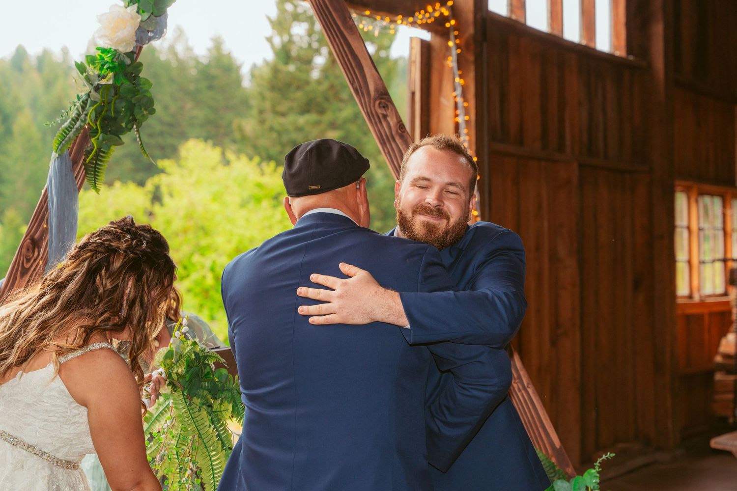 First look wedding moment captured in rustic barn venue with natural lighting and greenery decor.