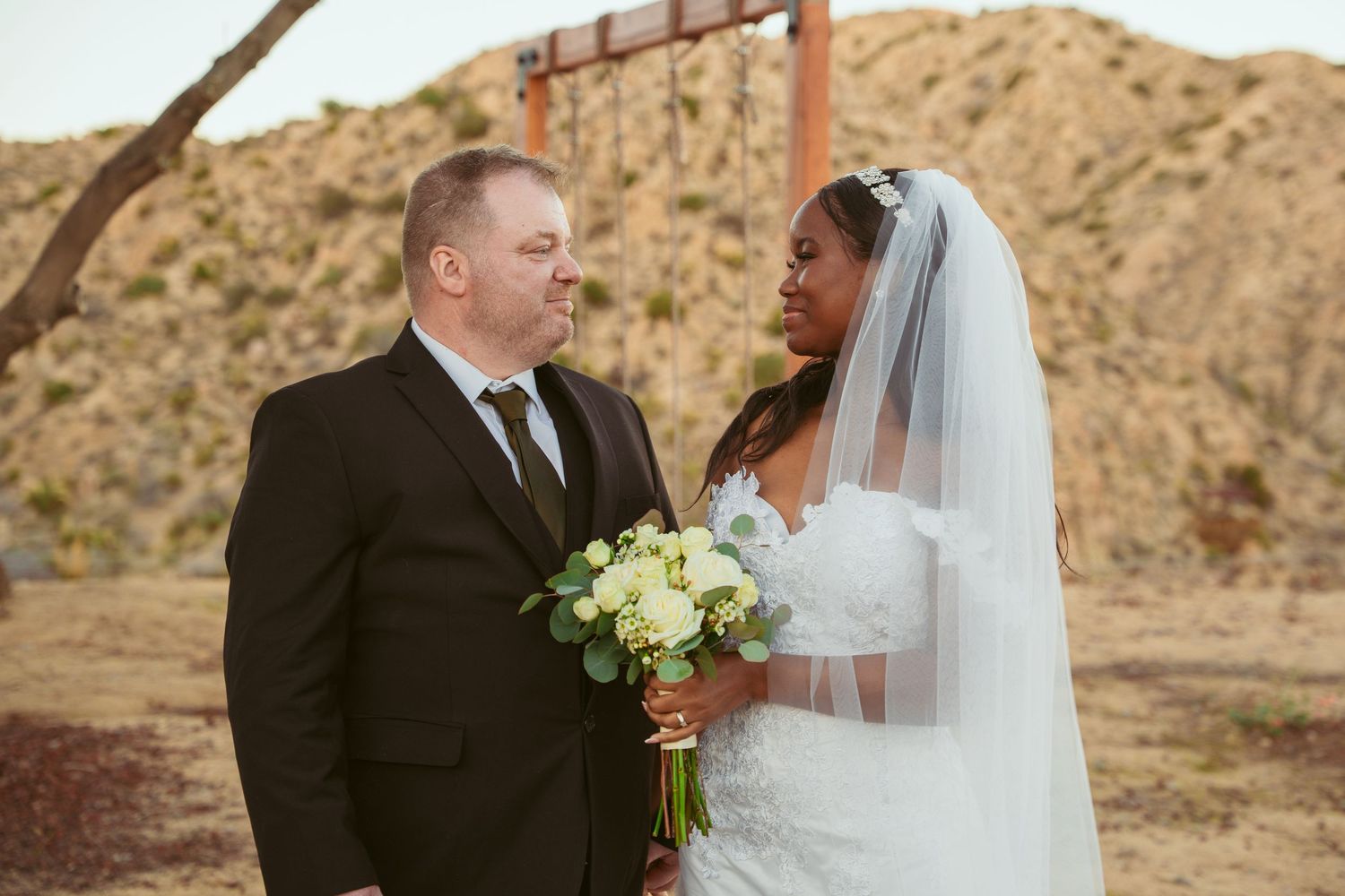 Wedding couple shares intimate moments during their desert ceremony with mountain views.