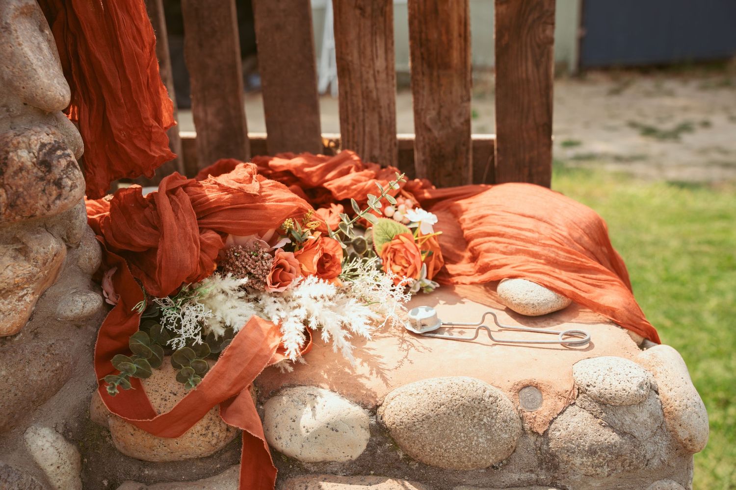 Decorative stone wall with orange fabric draping and floral accents.