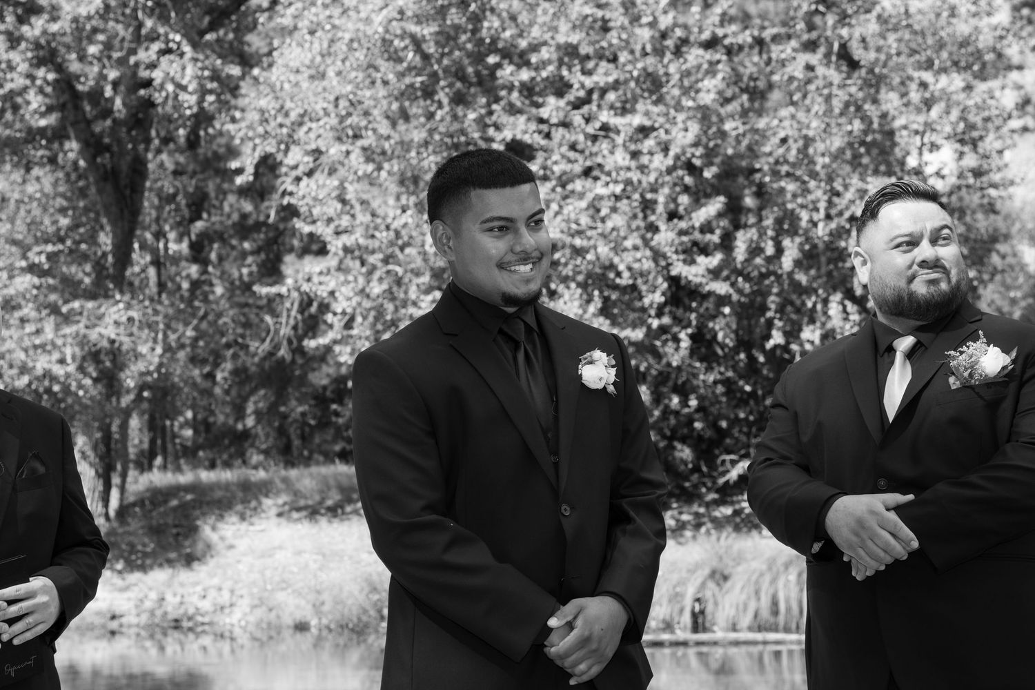Black and white photo of groomsmen sharing candid moments at Yosemite wedding.