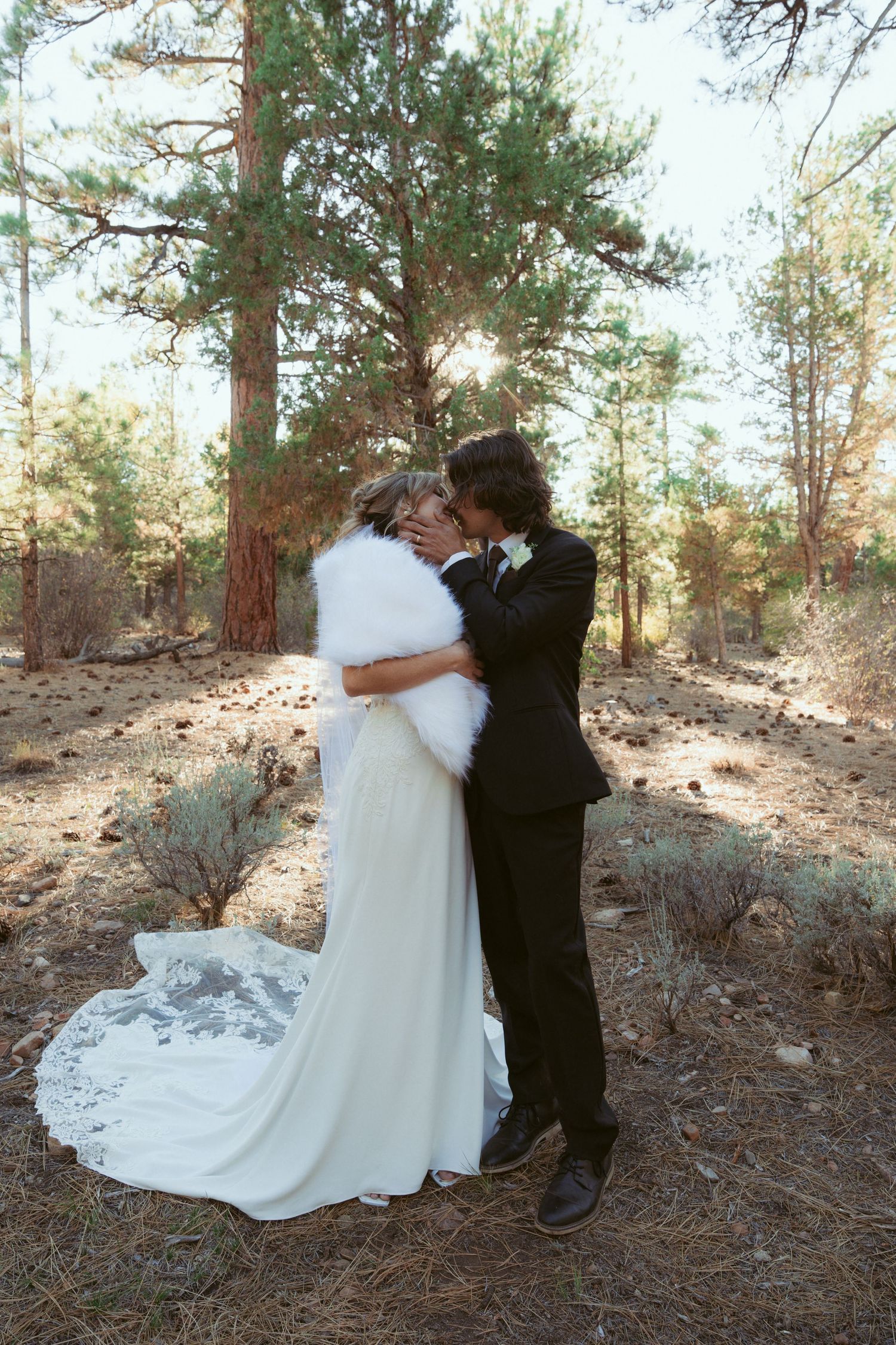 A romantic wedding dance moment photographed in a rustic forest setting.