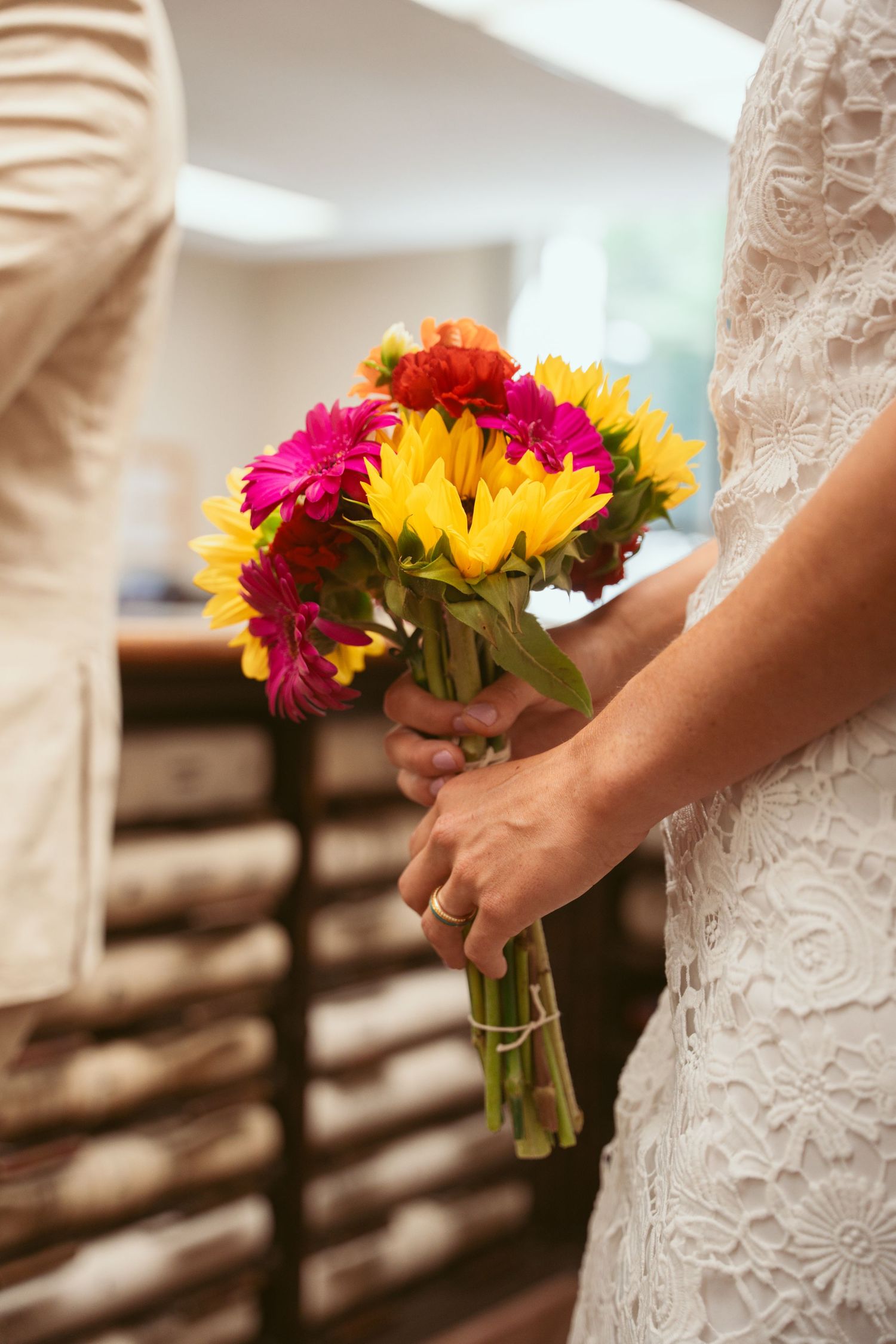 Close-up of bright gerbera daisies and sunflowers in wedding bouquets.