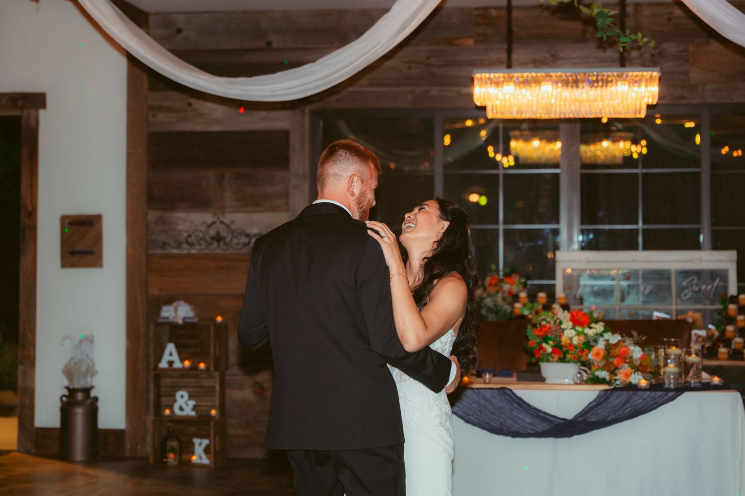 Elegant wedding venue decorated with white draping and chandeliers.