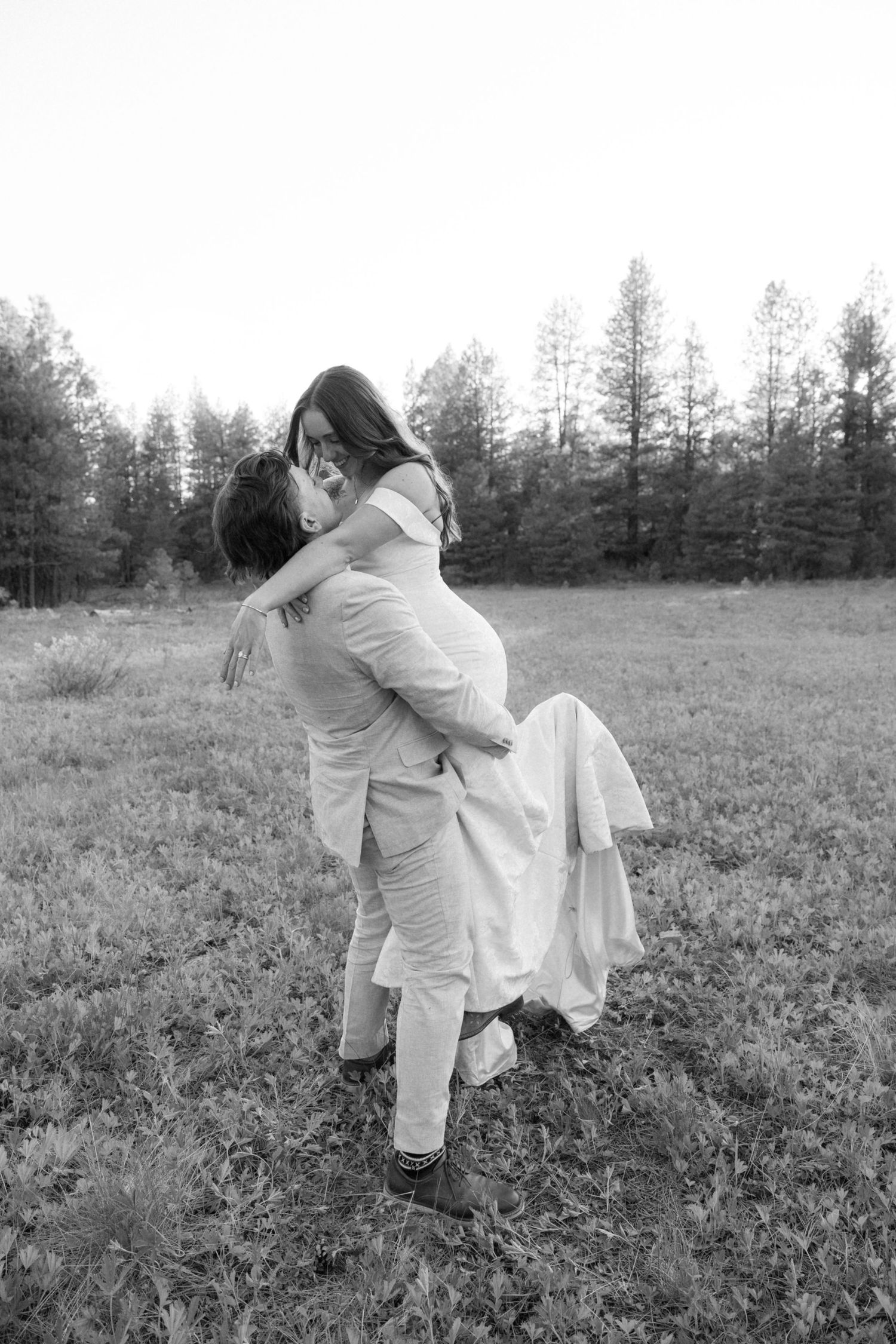 Black and white images capture romantic moments between newlyweds in a field.