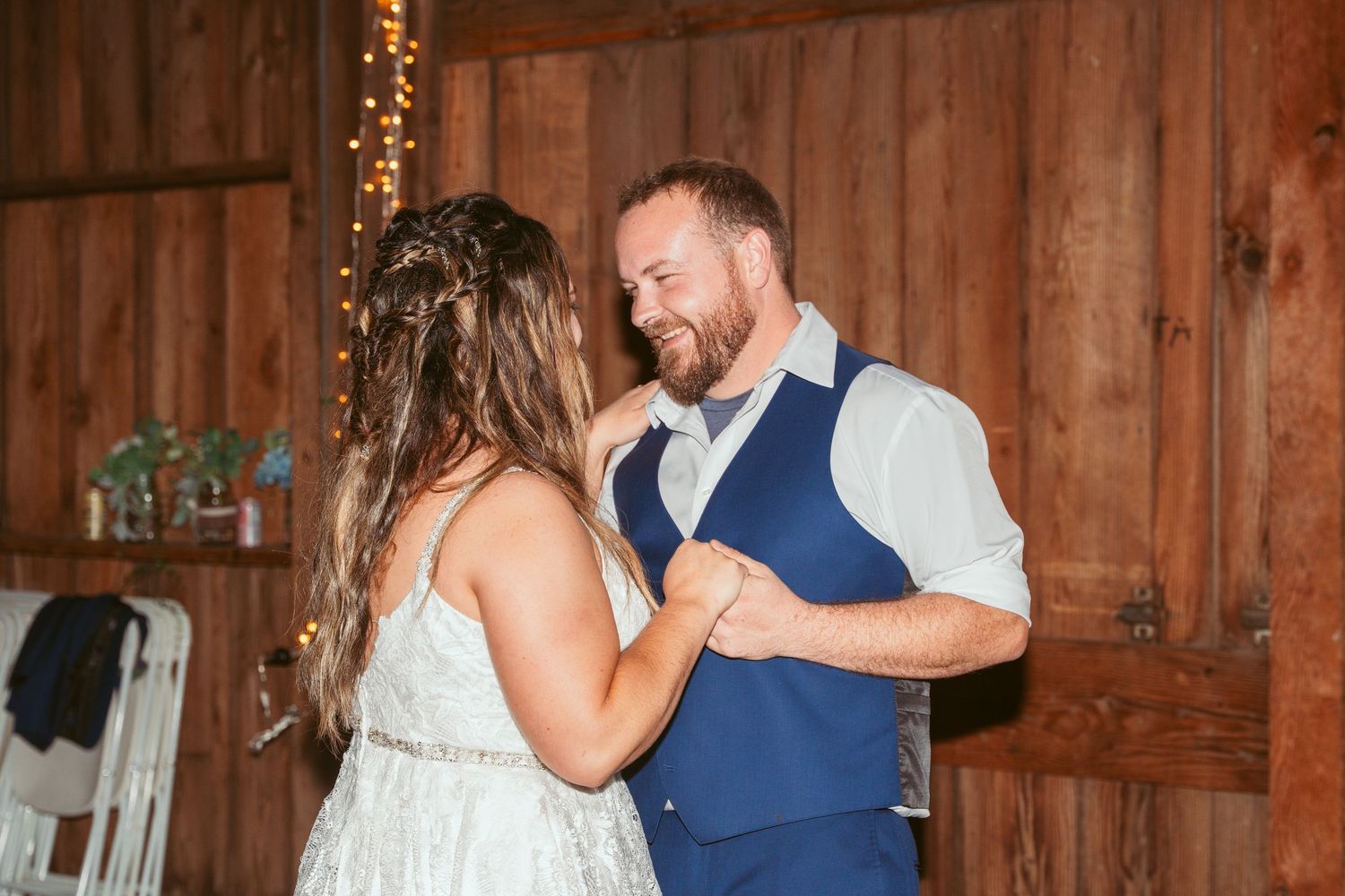 Two people slow dancing in an intimate moment on a barn dance floor.