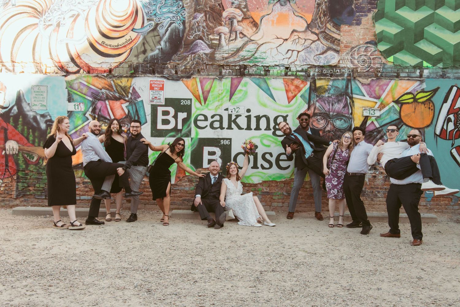 Crowd mingling in front of vibrant street art murals and graffiti.