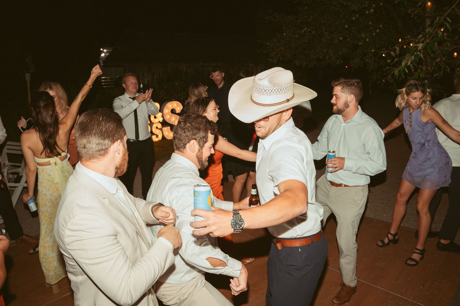 Guests dancing and mingling at a festive outdoor evening gathering.
