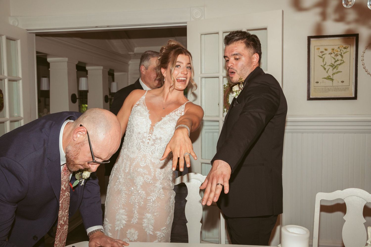 Wedding reception celebration inside a classic white-paneled room with vintage decor.