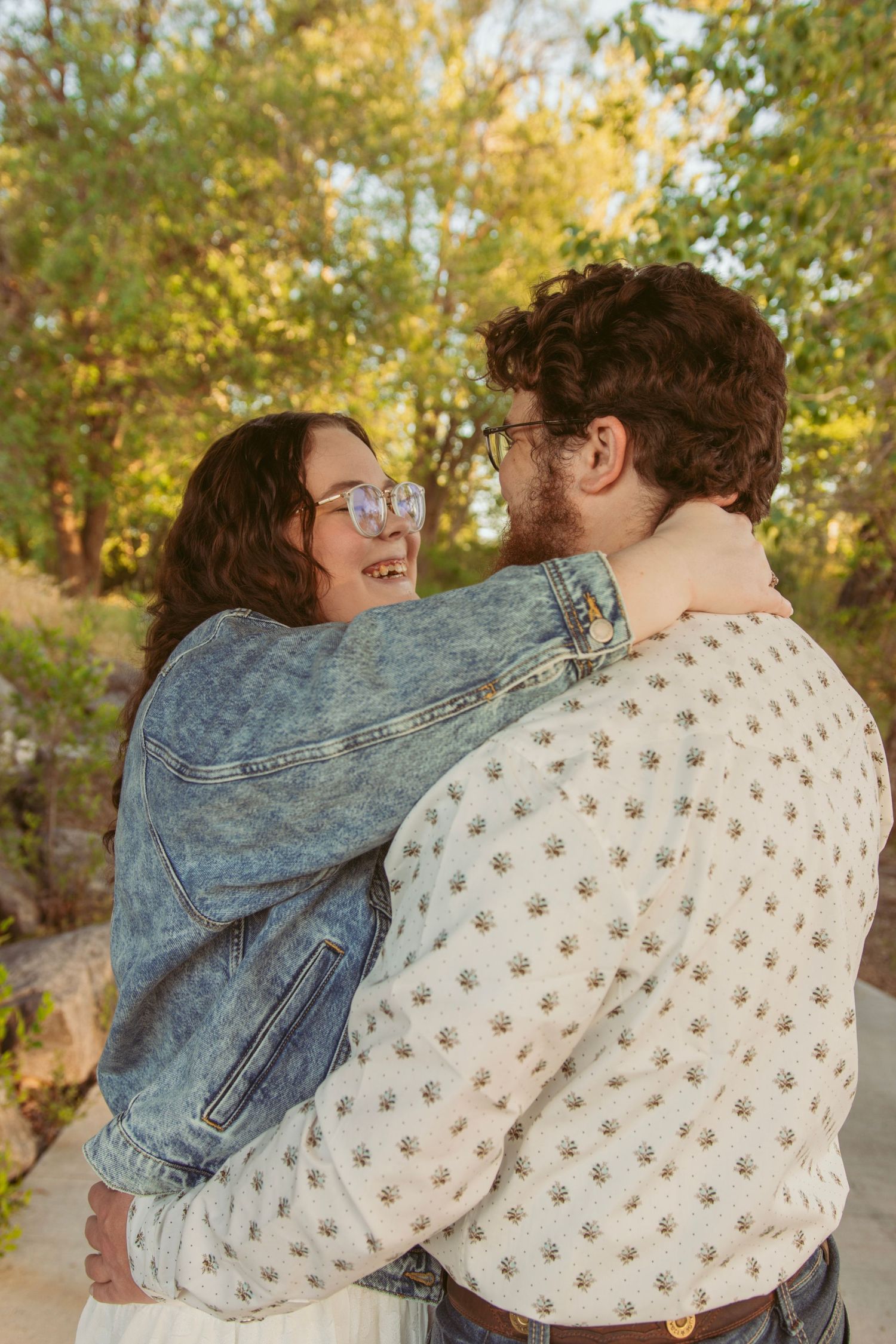 Tender embrace captured against autumn foliage during sunset.