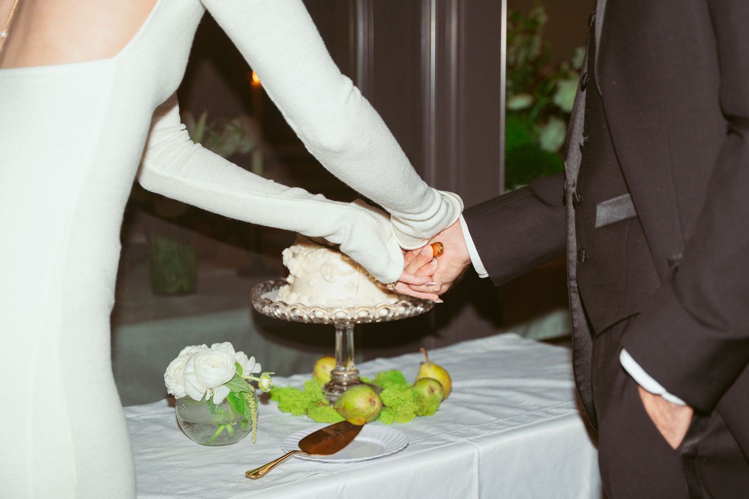 A couple playfully feeds each other wedding cake during a reception celebration.