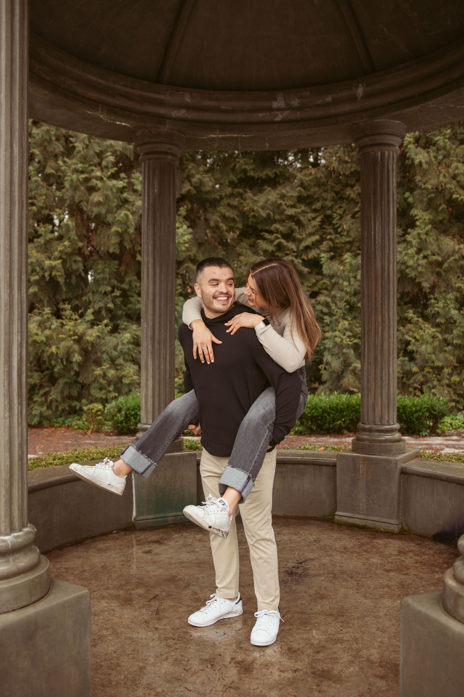 A joyful piggyback ride moment captured in an outdoor garden setting.