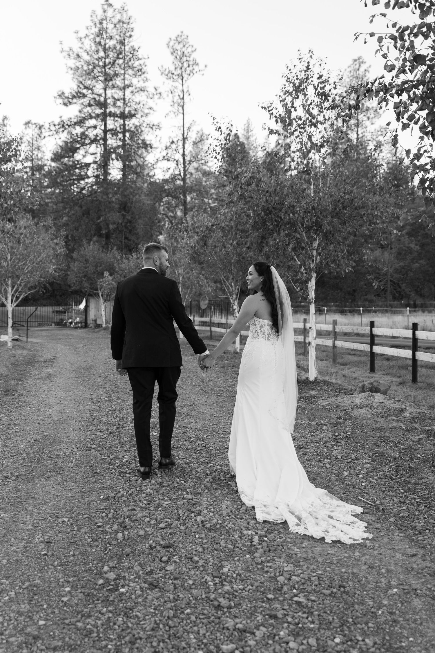 Wedding couple strolling through park with fall foliage in black and white.