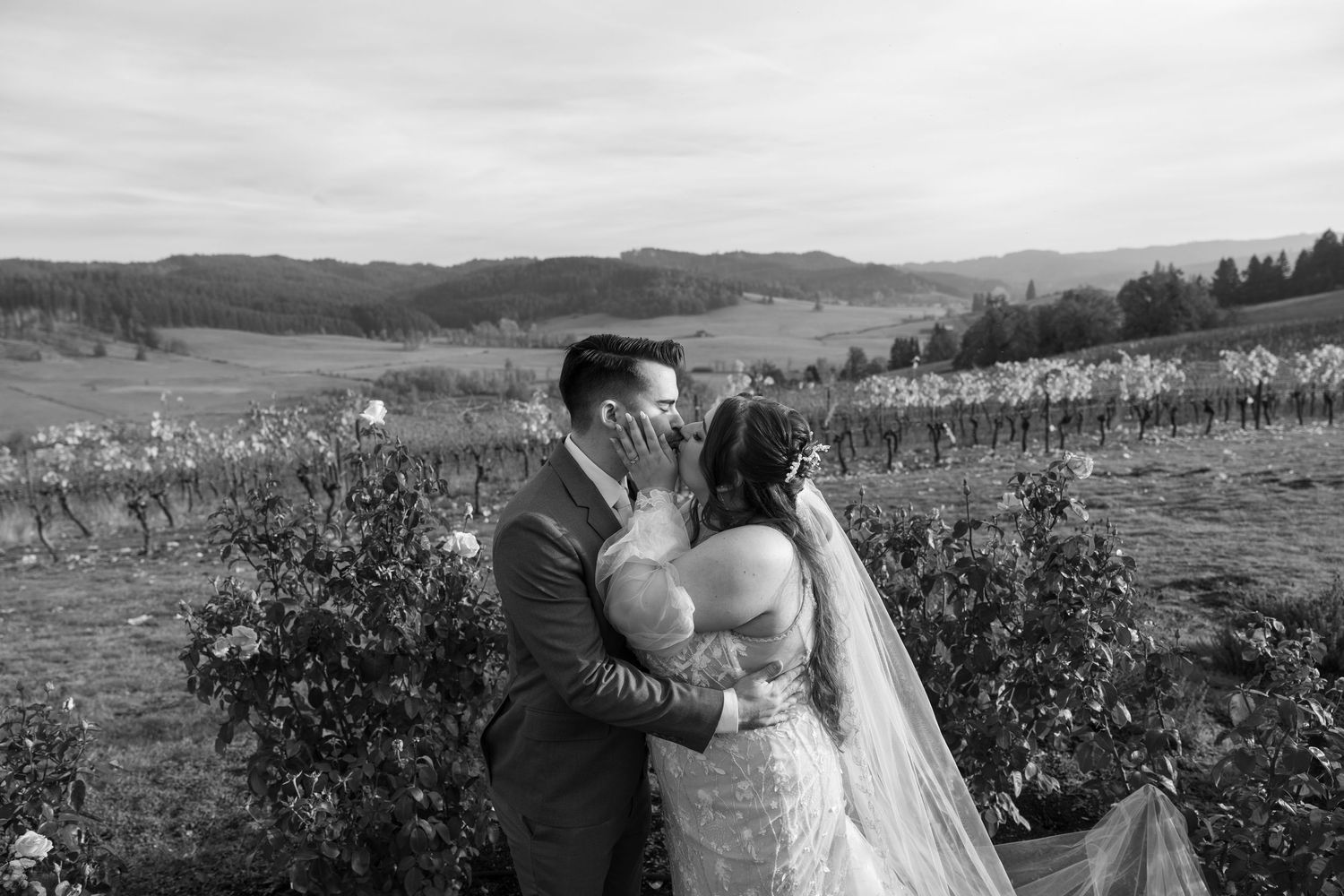 A romantic wedding moment captured in a vineyard with rolling hills and autumn colors in the background.
