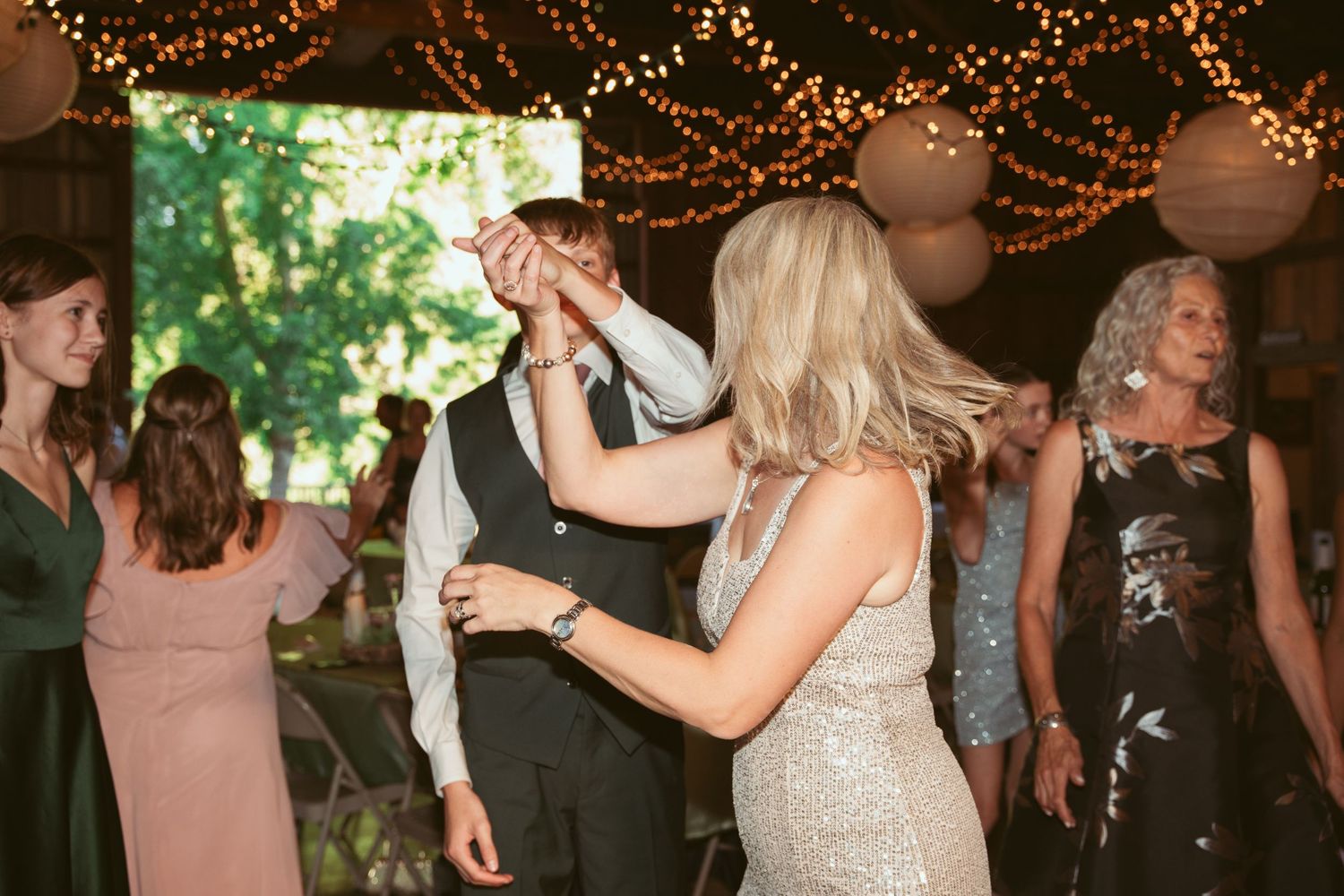 Joyful dancing and celebration at a rustic barn wedding reception.