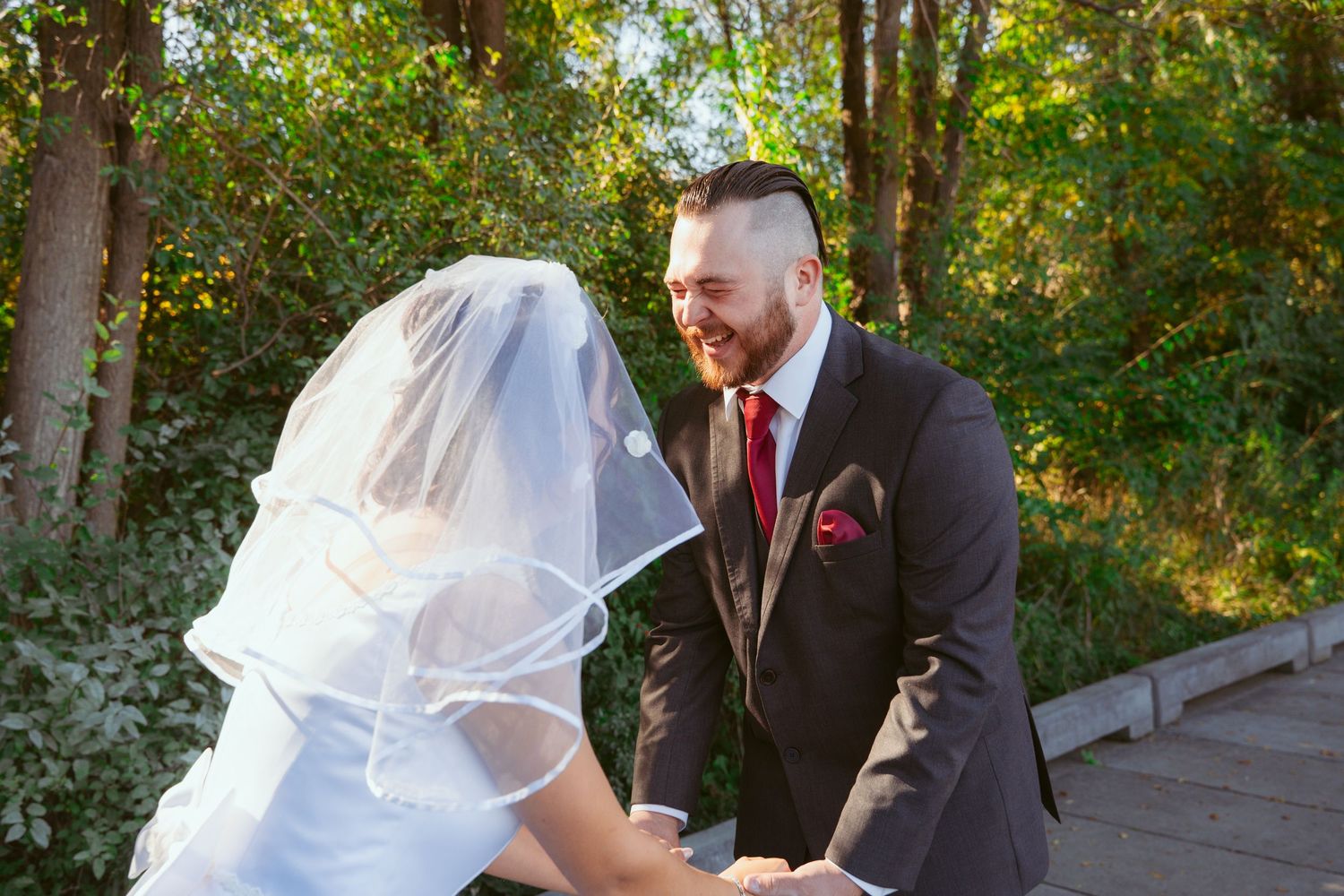 A couple shares a tender moment during their outdoor forest wedding.