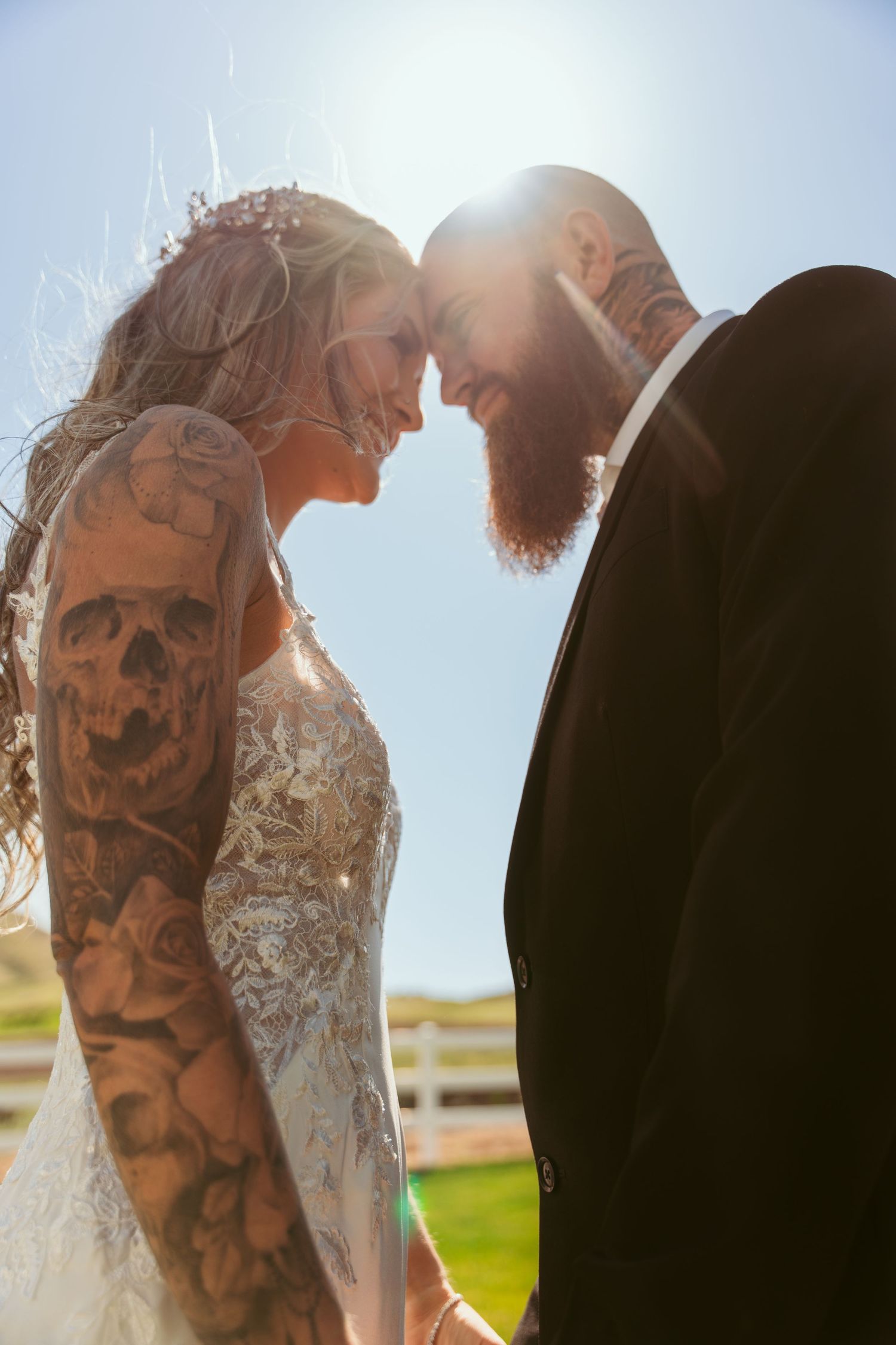 Silhouetted wedding couple sharing intimate moment in bright sunlight.