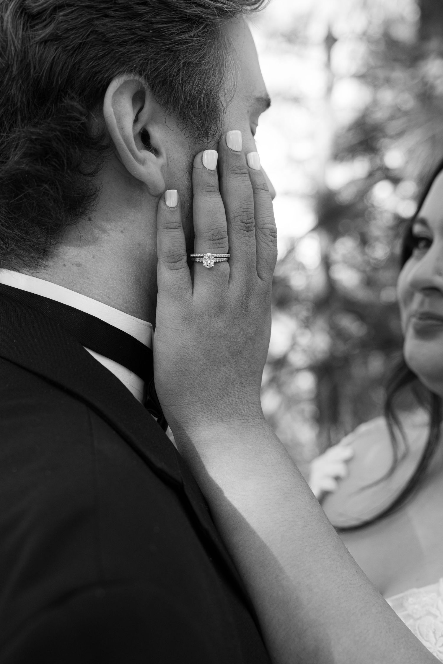 Black and white close-up of a wedding ring moment between the couple.
