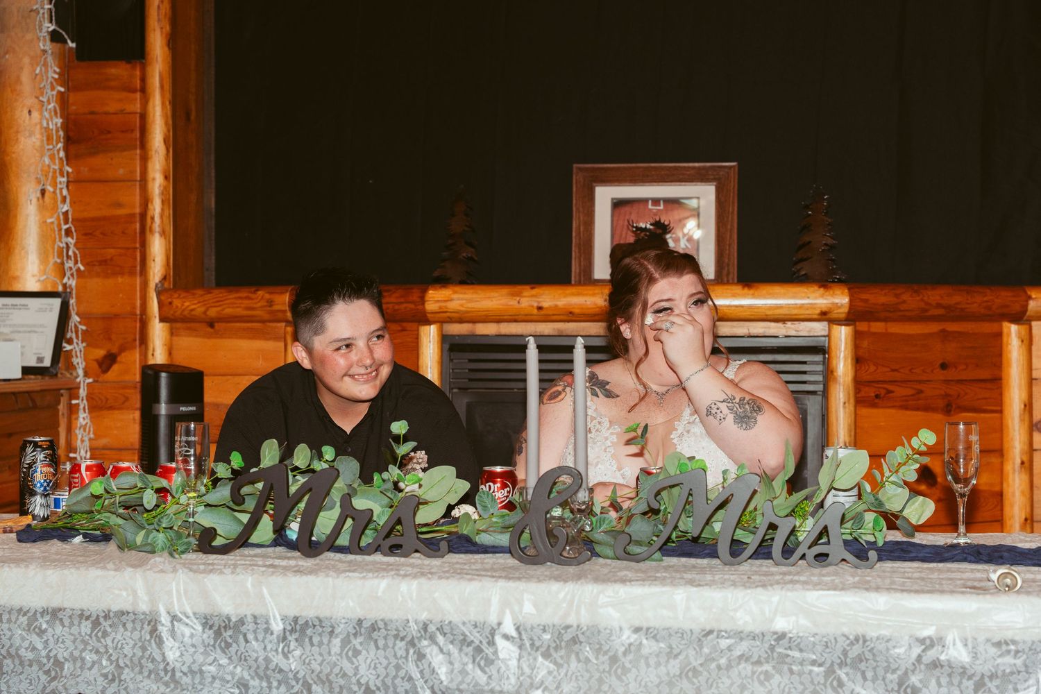 Wedding reception decor featuring wooden beams and greenery garlands.
